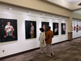 Photo of people in a gallery looking at artwork.